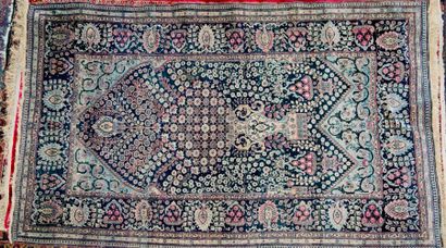 Tapis à fond bleu nuit à décor d'un vase...