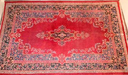 Iran. Tapis fait main, à fond rouge et bordure...