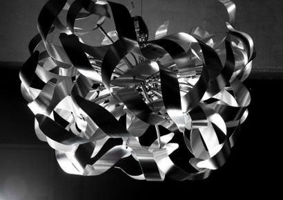 Grand lustre à lamelles d’inox brossé torsadées...