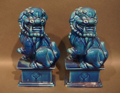 Paire de chiens de Fô en faïence bleue (éclats)....