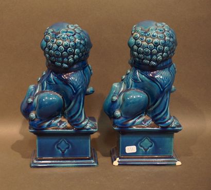 Paire de chiens de Fô en faïence bleue (éclats)....