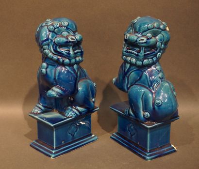 Paire de chiens de Fô en faïence bleue (éclats)....