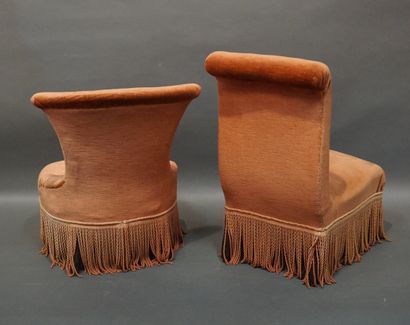 Two pink velvet armchairs with blackened...