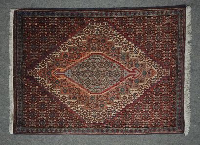 Small rug with geometric cartouche on burgundy...