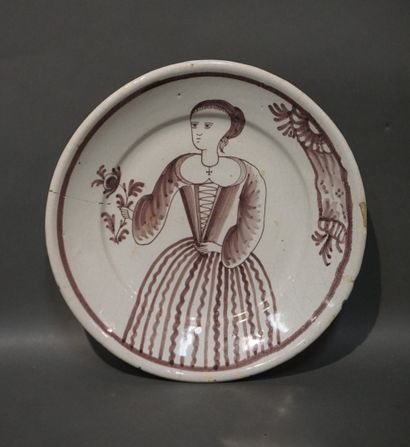 Plat en faïence à décor manganèse de femme...
