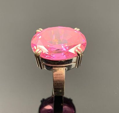Bague en or blanc ornée d'une pierre rose.

Tour...