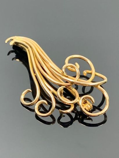 Broche en or jaune figurant des volutes.

H_5...