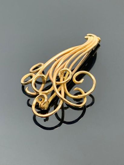 Broche en or jaune figurant des volutes.

H_5...