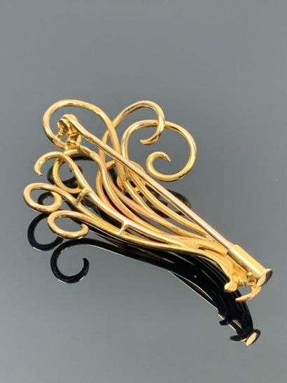 Broche en or jaune figurant des volutes.

H_5...