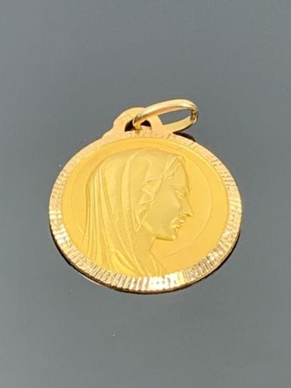 Médaille en or jaune figurant une Vierge.

D-2...
