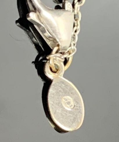 Collier en or blanc retenant un coeur orné...