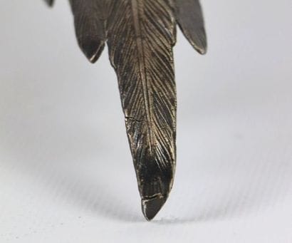 Faisan en argent, une patte levée.

H_11...