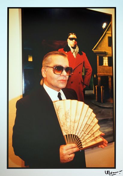Karl Lagerfeld in front of the portrait of...