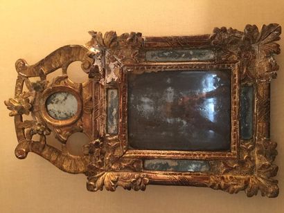Miroir en bois doré à pare-closes à décor...
