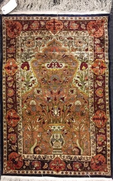 Tapis HEREKE en soie à décor d'un vase fleuri...