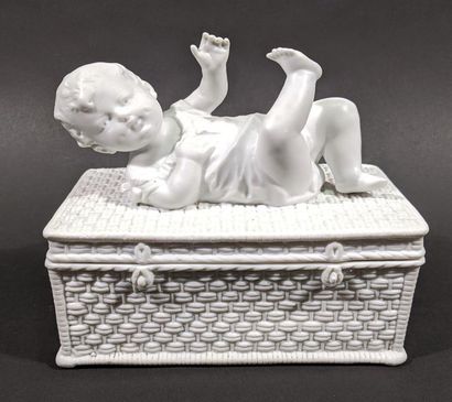 Bébé couché sur une boite imitant une panière...