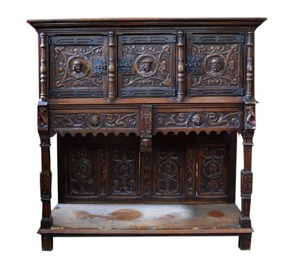 A richly carved oak credenza with portraits...