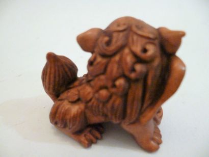 Boxwood netsuke of a standing shishi with...
