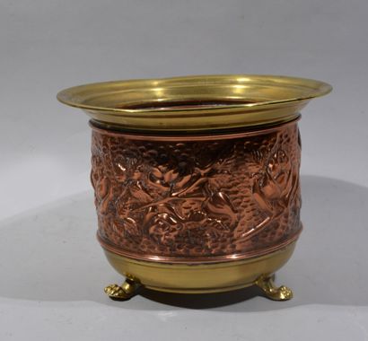 Brass and copper planter resting on three...