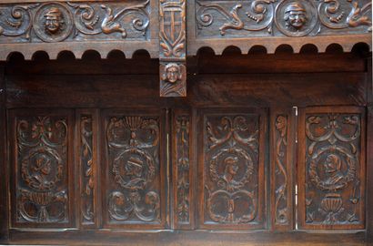A richly carved oak credenza with portraits...