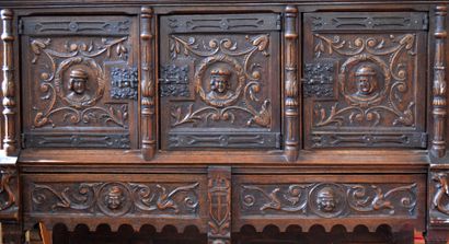 A richly carved oak credenza with portraits...