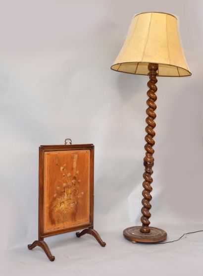 A twisted wooden floor lamp resting on a...