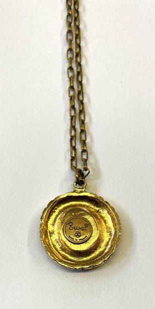 CHANEL

Médaillon en métal doré à décor du...