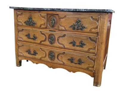 Commode galbée en chêne mouluré et sculpté....