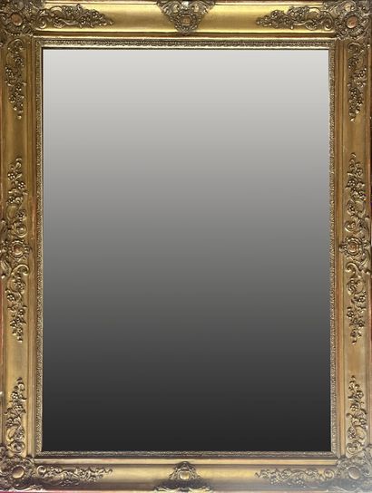 MIROIR en bois et stuc doré à décor de cartouches...