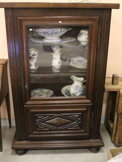 VITRINE en chêne, ouvrant par une porte....