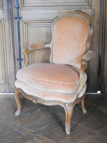A cabriolet armchair in natural wood molded...