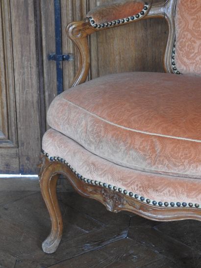 A cabriolet armchair in natural wood molded...