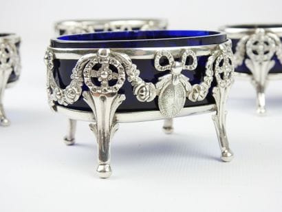 Suite of four silver salerons of oval form...