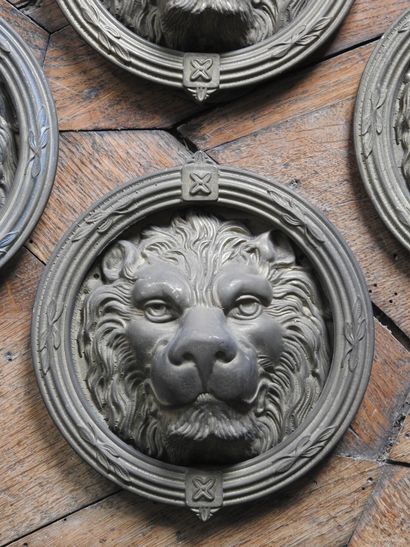 Suite of four bronze knockers with lion heads....