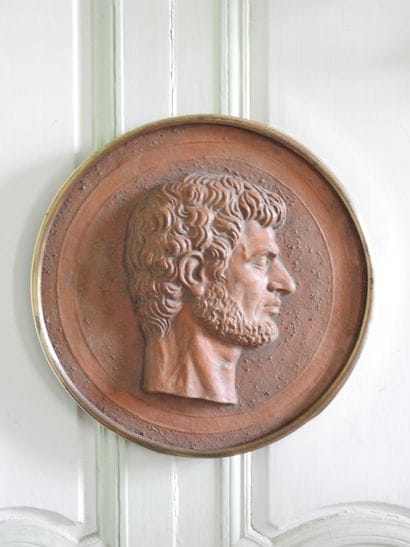 Terracotta medallion encircled with gilt...