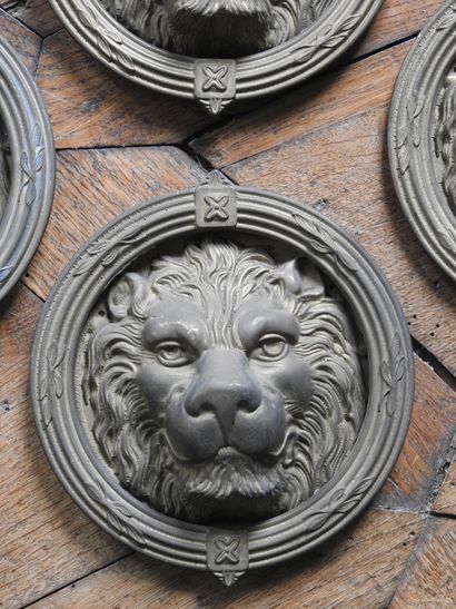 Suite of four bronze knockers with lion heads....