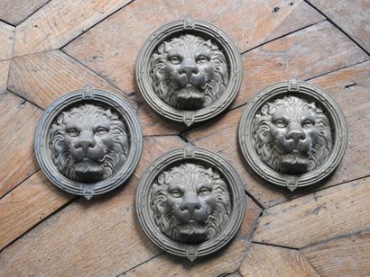 Suite of four bronze knockers with lion heads....