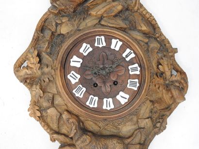 Carved wood wall clock decorated with an...