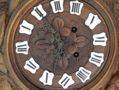 Carved wood wall clock decorated with an...