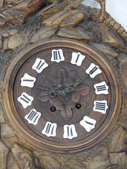 Carved wood wall clock decorated with an...