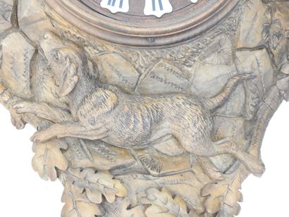 Carved wood wall clock decorated with an...