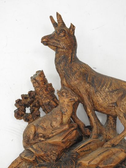 Carved wood wall clock decorated with an...