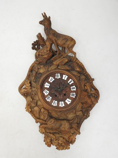 Carved wood wall clock decorated with an...
