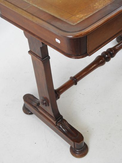 A mahogany desk resting on a base joined...