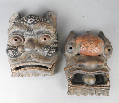 TIBET: Two carved wooden grimacing masks....