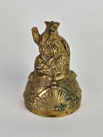 Cloche en bronze ciselé et doré surmontée...