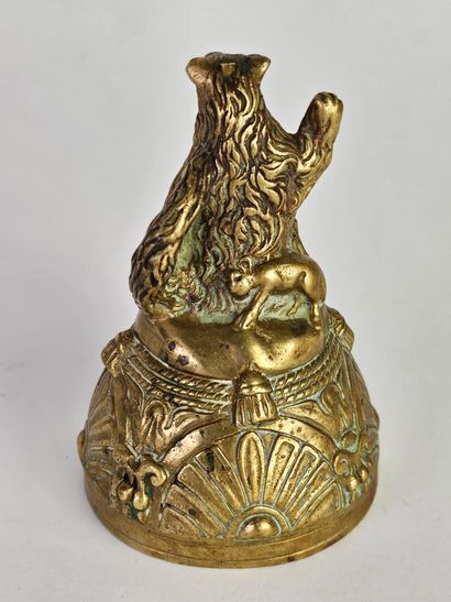 Cloche en bronze ciselé et doré surmontée...