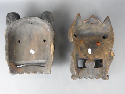 TIBET: Two carved wooden grimacing masks....