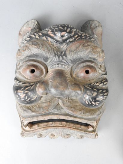 TIBET: Two carved wooden grimacing masks....