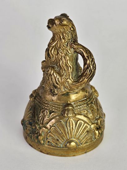 Cloche en bronze ciselé et doré surmontée...